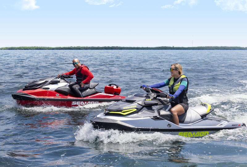 Sea-Doo GTI Ein Mann und eine Frau auf Jetbooten mit Zubehör für den Sea-Doo GTI auf einem See.