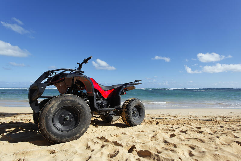 Ein rotes Quad steht an einem Strand.